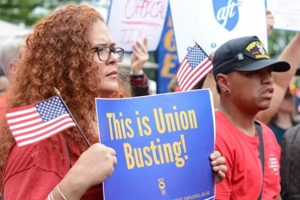 Woman holding "This is union busting!" sign