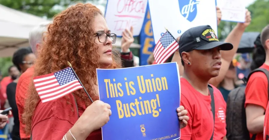 Woman holding "This is union busting!" sign